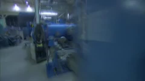 A fast tracking shot moving down an industrial hallway past laboratory equipment.
