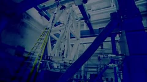 Large white metal lattice structure undergoing testing in an industrial facility