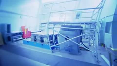 Large grey industrial testing machine positioned inside a spacious cleanroom