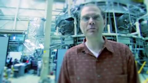 Man speaking in a cleanroom, followed by a close-up of a metal grating