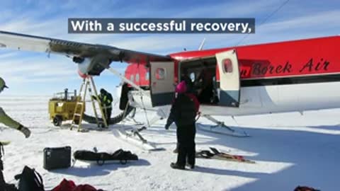 Scientists boarding red airplane on snow runway after successful recovery.