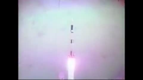 Rocket launching into the sky viewed from below with white exhaust plume