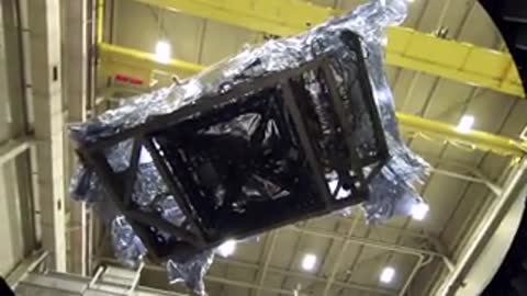 The instrument module hanging suspended in mid-air inside the expansive testing hall