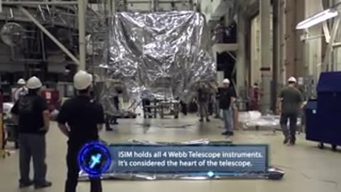 Numerous technicians and engineers observing the suspended cargo module in the workshop