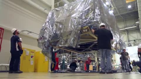 Engineers positioning the massive covered structure safely onto the facility floor level