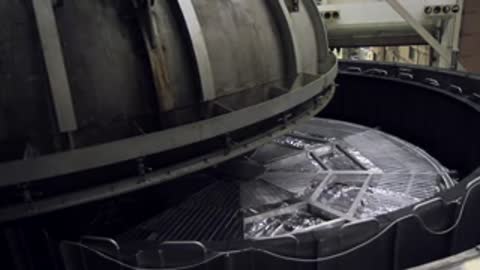 Mechanical lid rising to reveal the wrapped instrument module inside the deep chamber