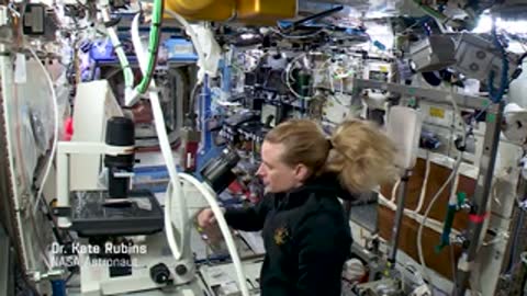 An astronaut working near scientific equipment with floating hair