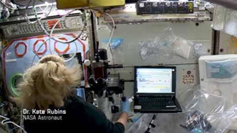 An astronaut working at a laptop inside the space station