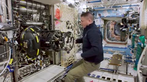An astronaut working with equipment inside the space station