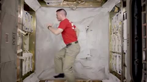 An astronaut flipping and floating inside the station module