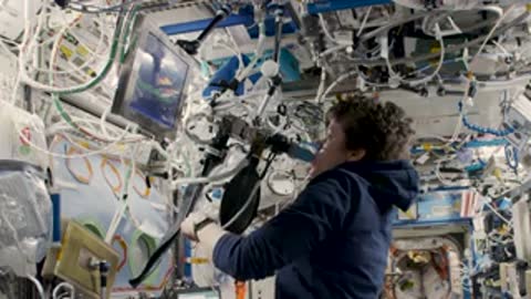 An astronaut using communication equipment near the ceiling