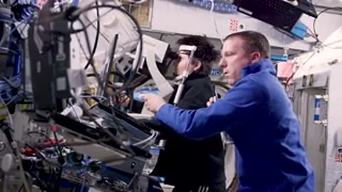 Two astronauts operating complex machinery together
