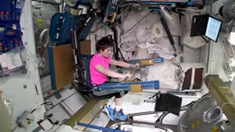 An astronaut exercising on a specialized machine in space
