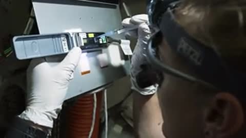 Close-up of gloved hands operating tool.