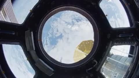 Earth view through ISS round window.