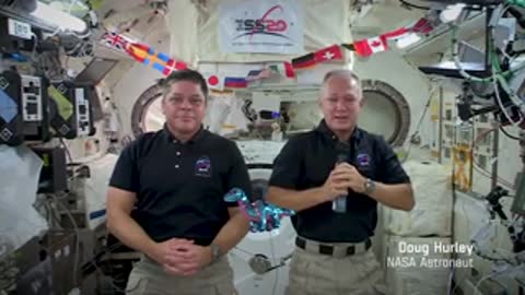 Two astronauts speaking on camera in ISS.