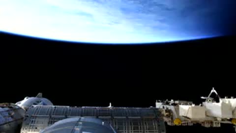 Atmospheric horizon curving above ISS structure.