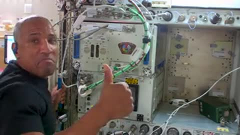An astronaut smiling and giving a thumbs up