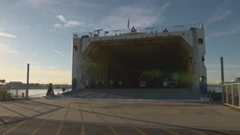 Wide shot of the open cargo bay of a large vessel at sunrise.