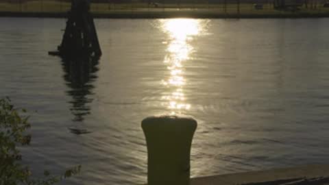 Static medium shot of sunlight reflecting brightly off the surface of water.