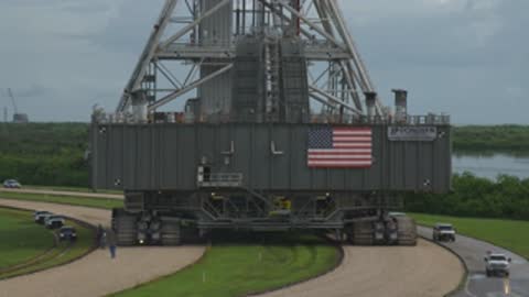 Medium close-up of the mobile launcher base moving along the crawlerway.