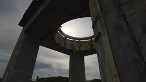 Low angle view looking up through the circular opening between concrete pillars