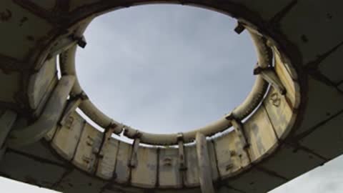 Upward panning view along the circular metal-ringed structure opening