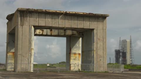 Medium shot of the concrete launch structure exterior with machinery in background