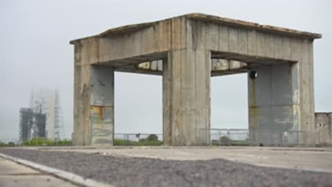Medium shot of an open-air concrete structure against an overcast sky.
