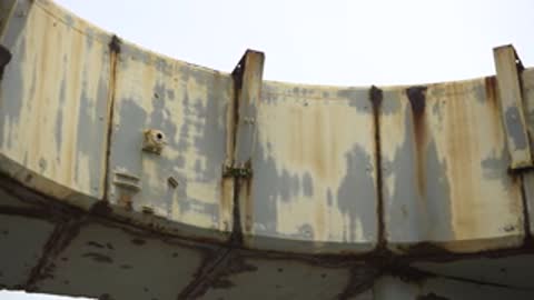 Close-up tracking shot along the curved edge of a concrete structure.
