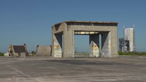 Wide shot of a concrete structure with distant buildings in the background.