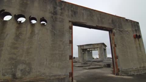 Medium shot looking through a doorway of a concrete ruin.