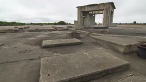Wide shot of concrete blocks and structures on a paved surface.