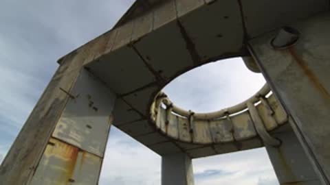 Upward tracking shot moving along the underside of the concrete structure roof