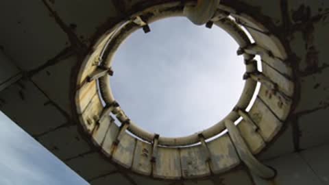 Rotating view framing the circular roof opening against the overcast sky