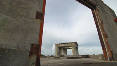 Looking through a heavy concrete doorway towards another structure on the platform