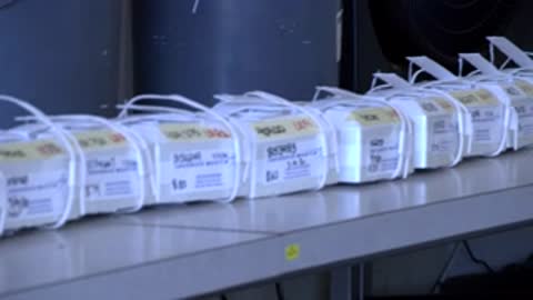 Close-up of a row of packaged weather sensor units sitting on a long table.