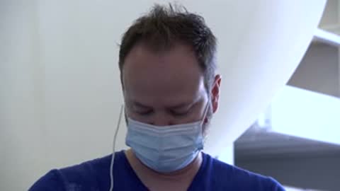 man wearing a face mask looks down inside a building