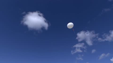 weather balloon ascending into a blue sky with scattered white clouds