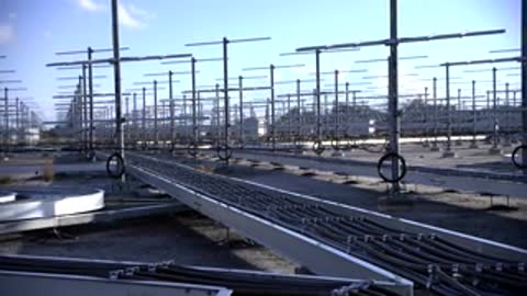Wide shot of structured metal towers and cable trays across the open field area.