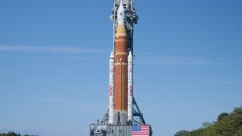 The SLS rocket rolls out along the crawlerway toward the launch pad.