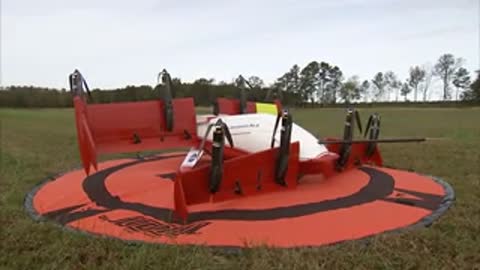 The assembled red and white aircraft sits on the round red launch pad.