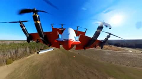 Forward-facing camera view from the aircraft flying low over fields and trees.