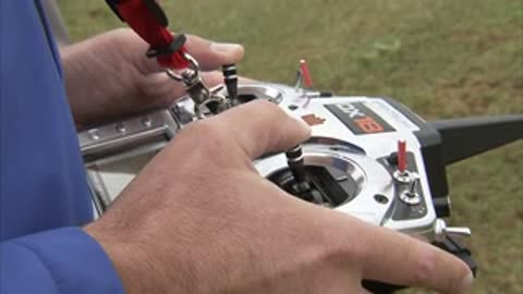 Close-up of hands operating the sticks and switches on a remote control.