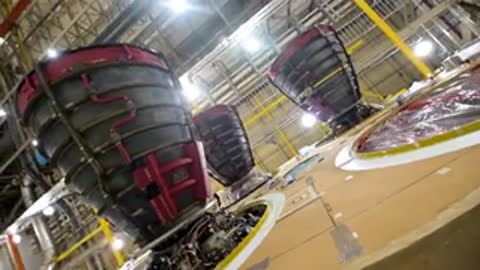 Medium upward shot of multiple rocket engine nozzles inside an assembly structure.