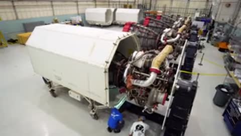 High-angle medium shot of large industrial equipment and components inside a clean room.
