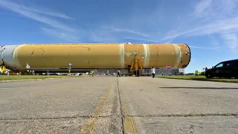 Side view of large rocket stage moving on transport vehicle