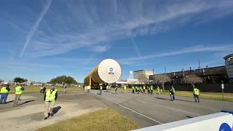 Rocket stage transport passing Michoud Assembly Facility sign