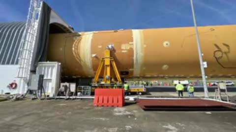 Rocket stage entering specialized transport barge facility exterior
