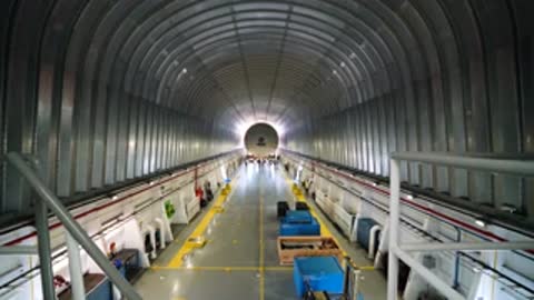 tracking shot moving forward down the long, empty interior corridor of a barge